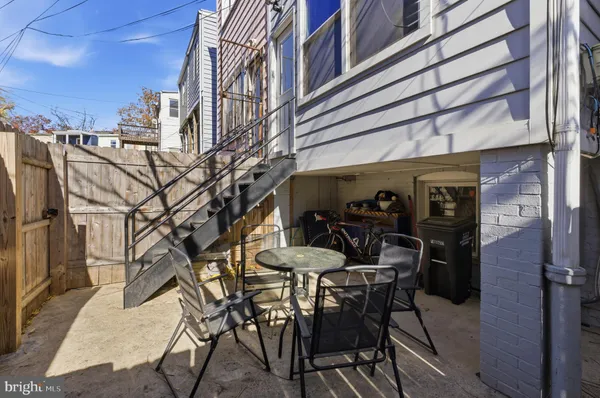 a view of a patio with a table and chairs and a barbeque
