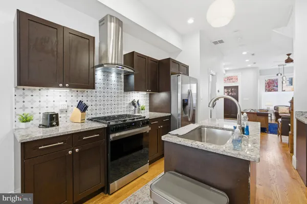 a kitchen with stainless steel appliances granite countertop a sink stove and refrigerator