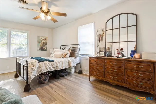 a spacious bedroom with a bed and a chandelier