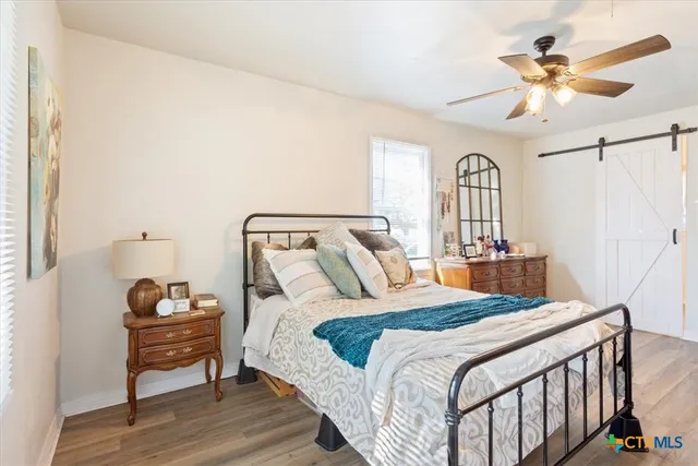 a bedroom with a bed chandelier and a window