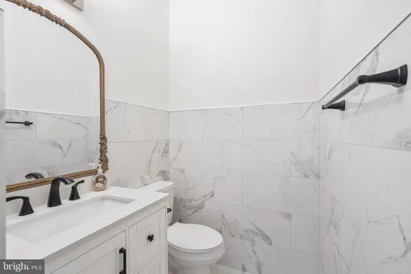 a bathroom with a sink vanity granite and toilet