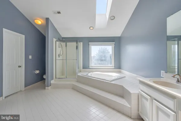a spacious bathroom with a granite countertop tub sink and mirror
