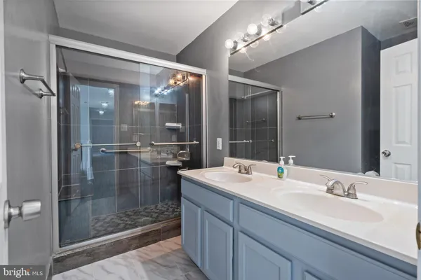 a bathroom with a shower sink and mirror