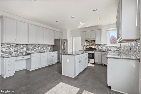 a kitchen with granite countertop white cabinets and white stainless steel appliances