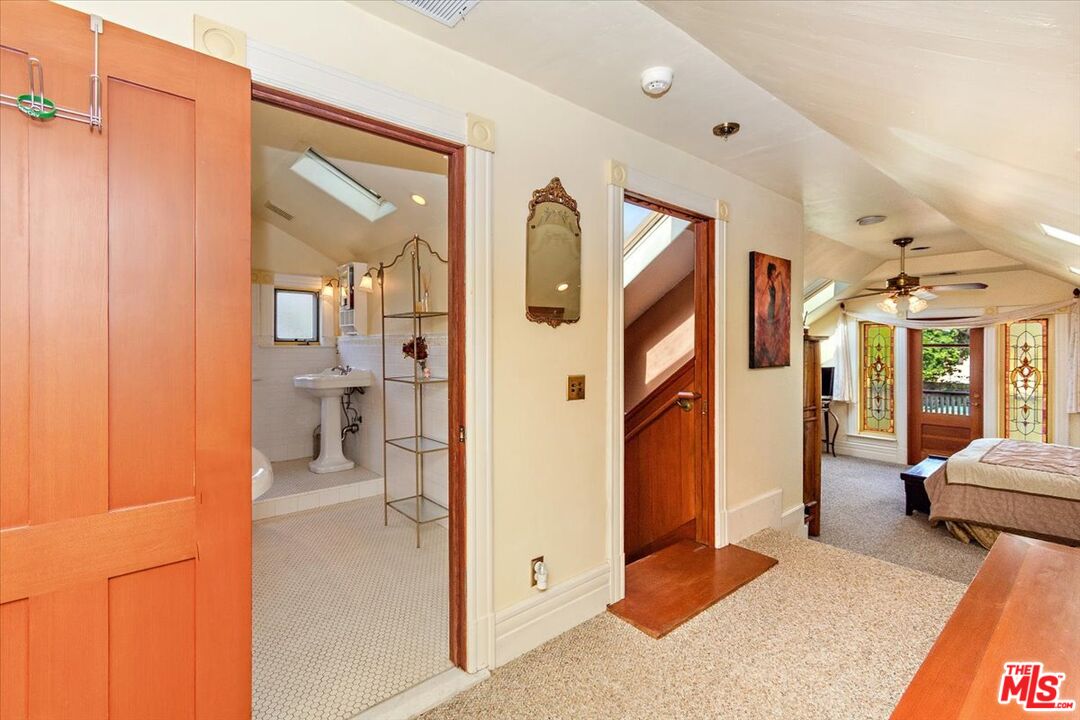 448 North Summit Avenue Pasadena, CA 91103 - Photo 11 of 16 a spacious bedroom with a large bed and a chandelier