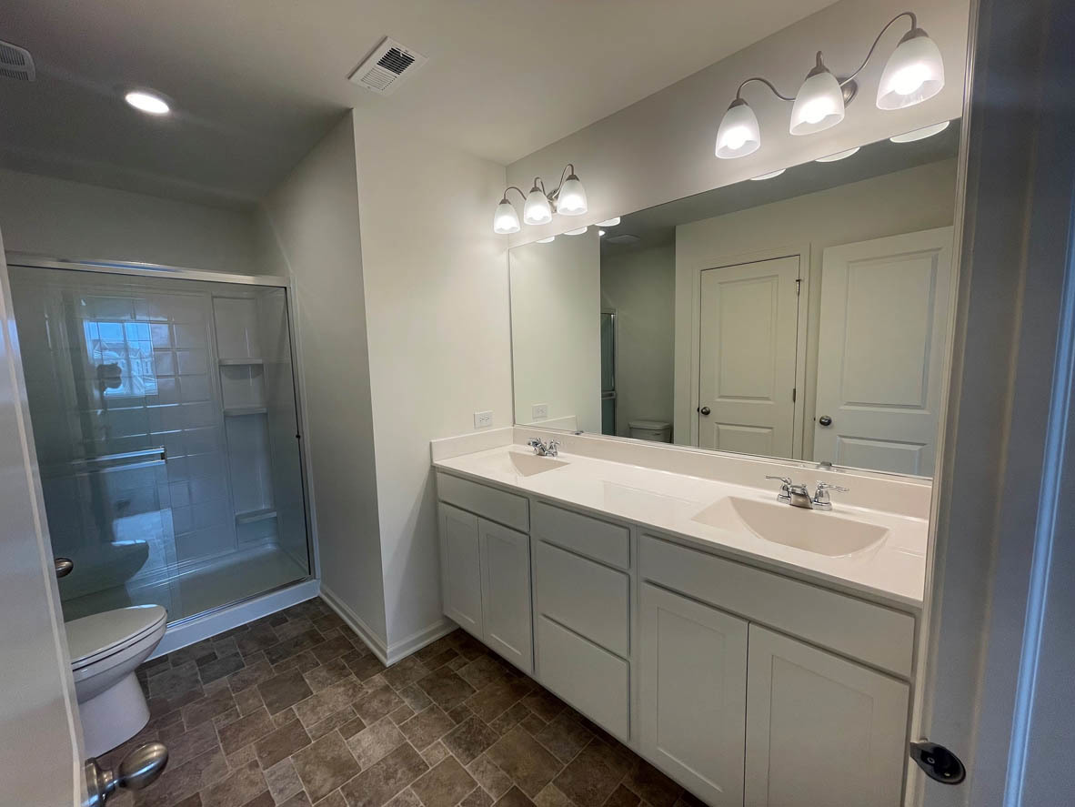 778 Westbury Drive Cary, IL 60013 - Photo 15 of 29 a bathroom with double vanity sink and a mirror