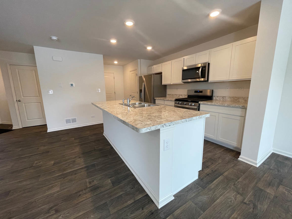 778 Westbury Drive Cary, IL 60013 - Photo 4 of 29 a kitchen with a sink a stove cabinets and wooden floor