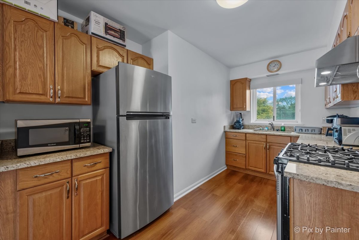7211 Division Street, Unit C2 River Forest, IL 60305 - Photo 12 of 22 a kitchen with stainless steel appliances a refrigerator stove and sink