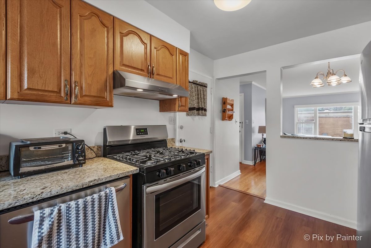 7211 Division Street, Unit C2 River Forest, IL 60305 - Photo 14 of 22 a kitchen with granite countertop wooden cabinets and a stove top oven