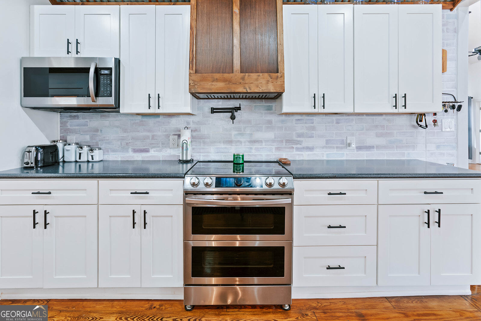 2820 Davis Academy Road Rutledge, GA 30663 - Photo 17 of 65 a kitchen with stainless steel appliances granite countertop a stove a microwave and cabinets