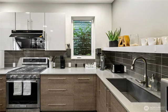 a kitchen with a sink a stove and cabinets