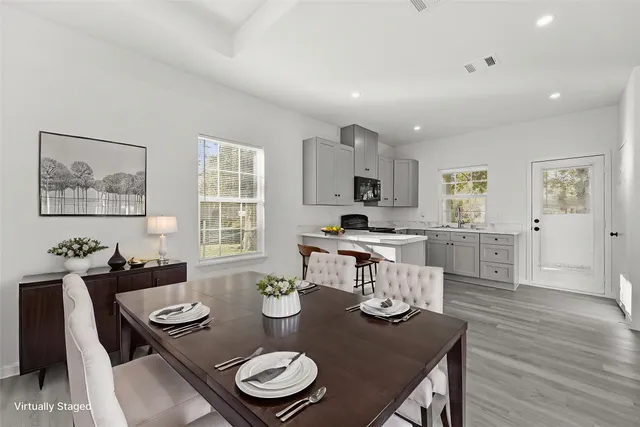 a open dining room with furniture kitchen view and wooden floor