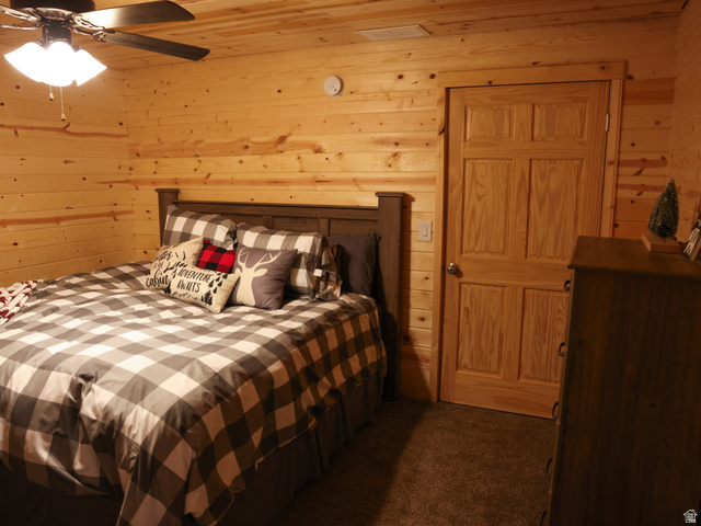 15253 Mill Road, Unit 62 Huntsville, UT 84317 - Photo 2 of 48 Room featuring wood-plank walls and ceiling, a paneled door with wood trim, and textured carpeting