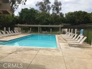 a view of backyard with swimming pool and seating space
