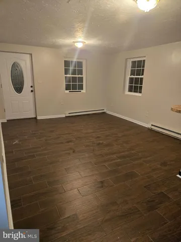 a view of a livingroom with wooden floor and window