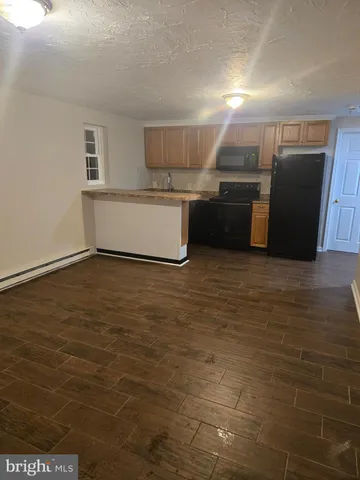 a view of kitchen cabinets microwave and refrigerator