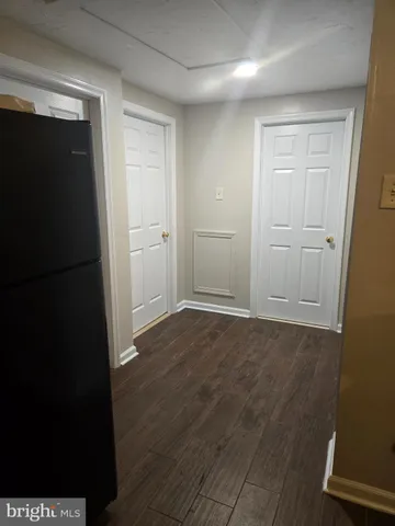 a view of an empty room with wooden floor and closet