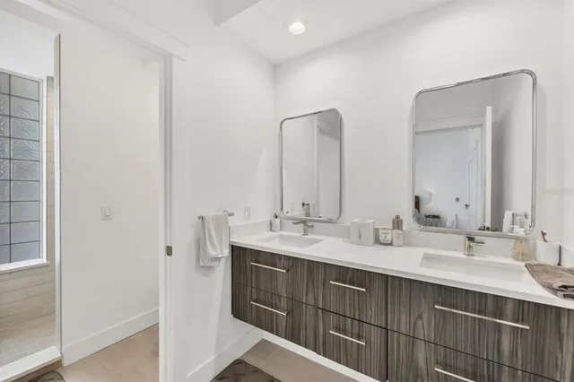 a bathroom with double vanity sinks and a mirror