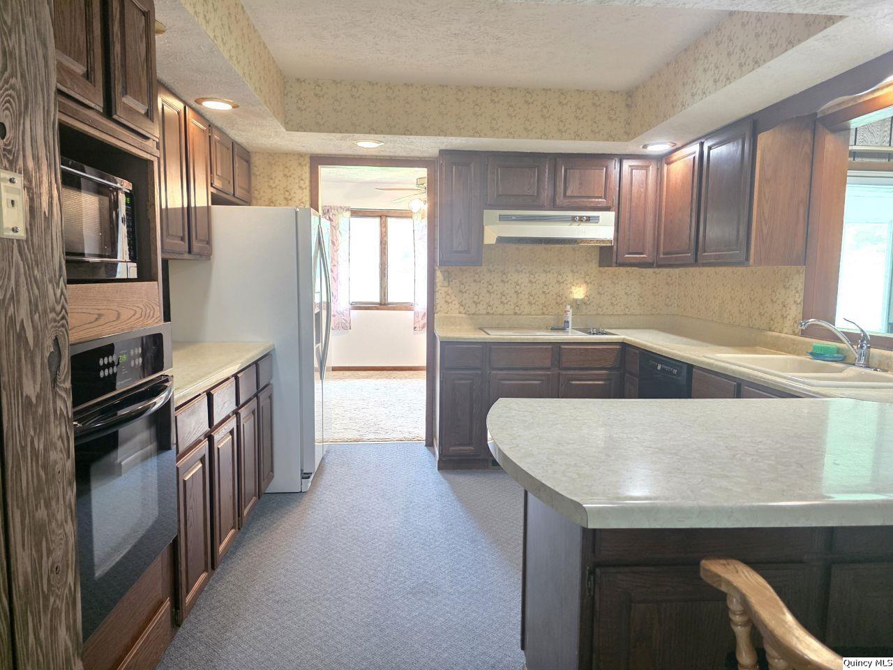502 North Chestnut Street Versailles, IL 62378 - Photo 16 of 32 a kitchen with stainless steel appliances granite countertop a sink stove and refrigerator