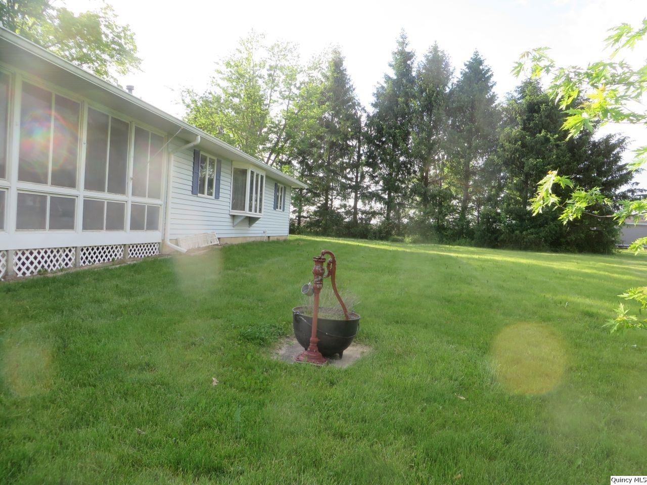 502 North Chestnut Street Versailles, IL 62378 - Photo 3 of 32 a front view of a house with a garden and yard