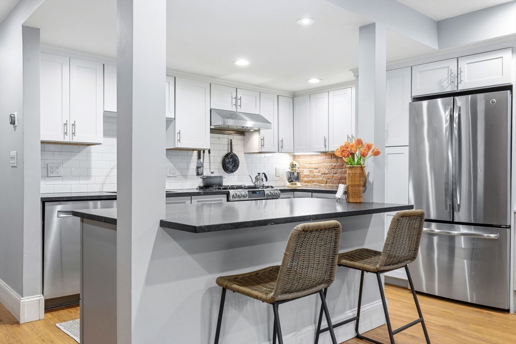 35 High Street, Unit 1 Boston, MA 02129 - Photo 23 of 33 a kitchen with kitchen island white cabinets and stainless steel appliances