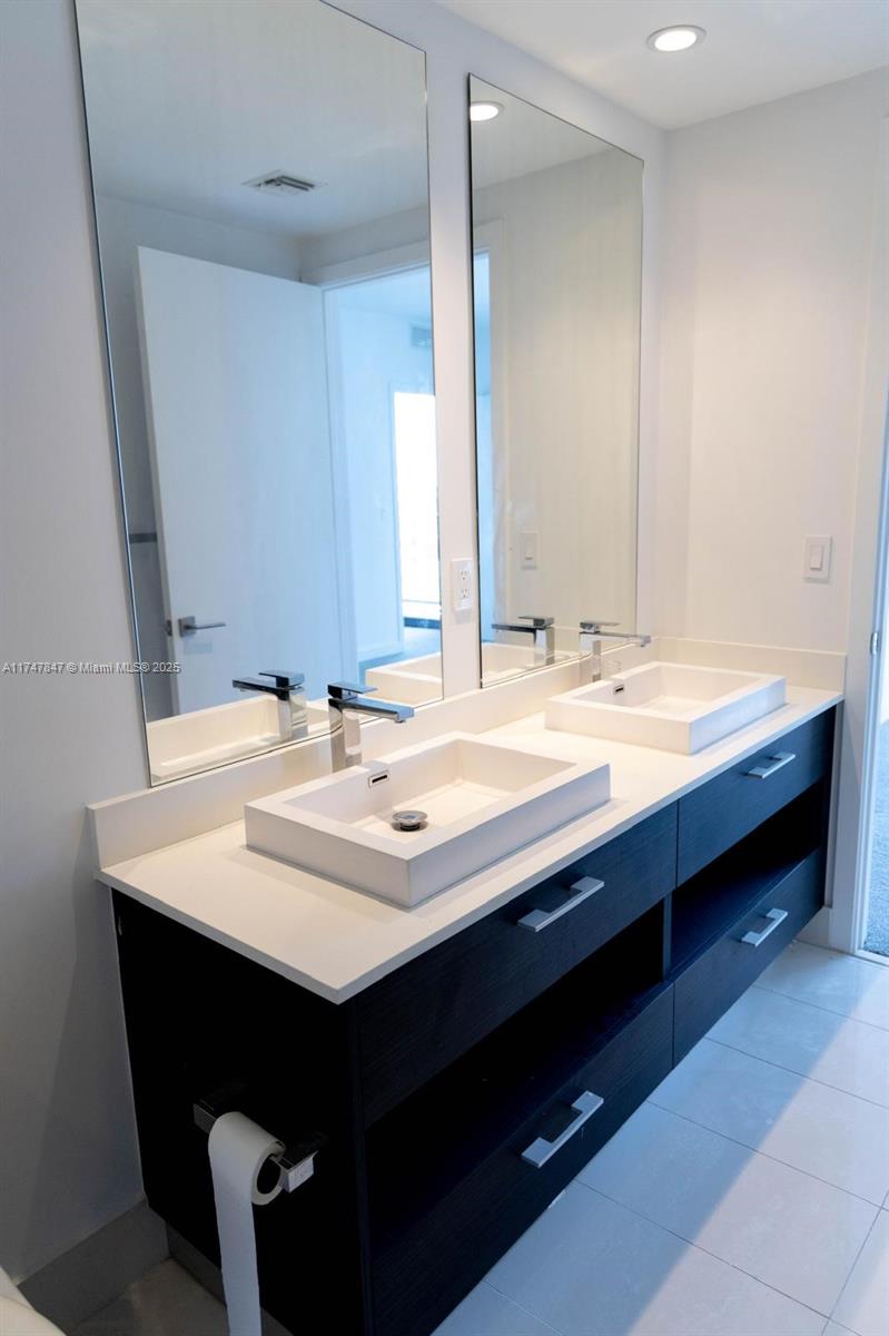 45 Southwest 9th Street, Unit 4703 Miami, FL 33130 - Photo 21 of 27 a bathroom with a sink double vanity and a mirror