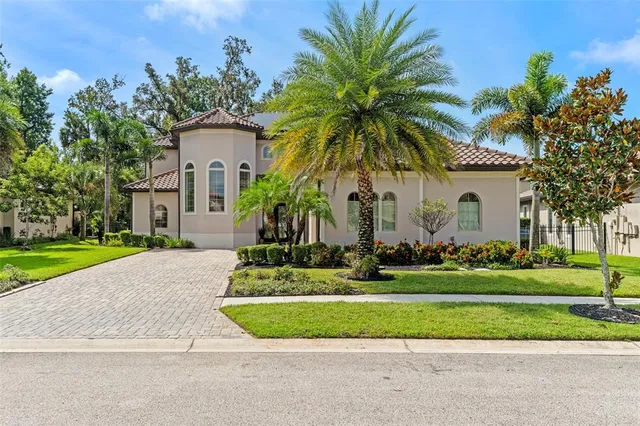 a front view of a house with a garden and palm trees