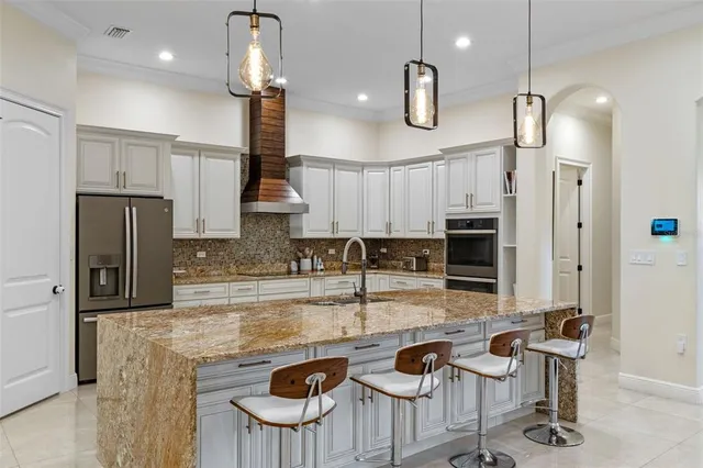 a kitchen with kitchen island granite countertop a sink stainless steel appliances and cabinets