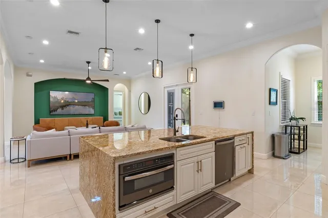 a kitchen with kitchen island granite countertop a counter space chairs appliances and cabinets