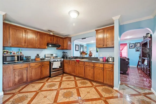 a kitchen with stainless steel appliances granite countertop a stove sink cabinets and a refrigerator