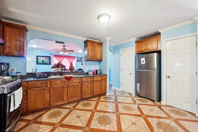 a large kitchen with stainless steel appliances granite countertop a refrigerator and a stove top oven