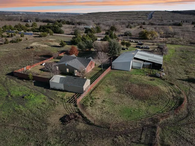 an aerial view of a house with a yard and mountain
