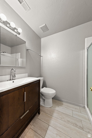 301 South 1200th Street East, Unit 31 St. George, UT 84790 - Photo 5 of 21 Bathroom featuring vanity, a textured wall, wood tiled floors, a shower stall, and a textured ceiling