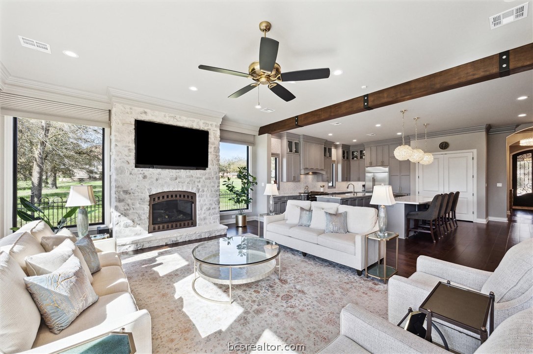 5202 Bourrone Court Bryan, TX 77802 - Photo 11 of 43 Open concept Living area with dark wood-flooring, beamed ceiling, and crown molding.
