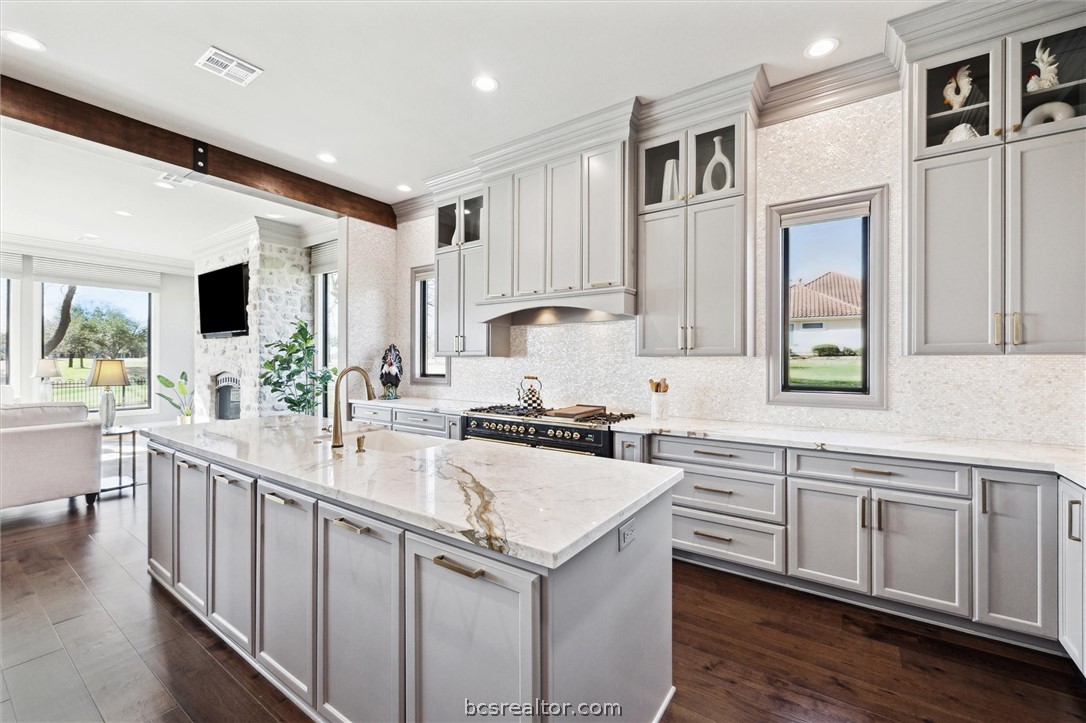 5202 Bourrone Court Bryan, TX 77802 - Photo 13 of 43 Kitchen with double oven range, warming drawers, beverage cooler with light stone countertops.