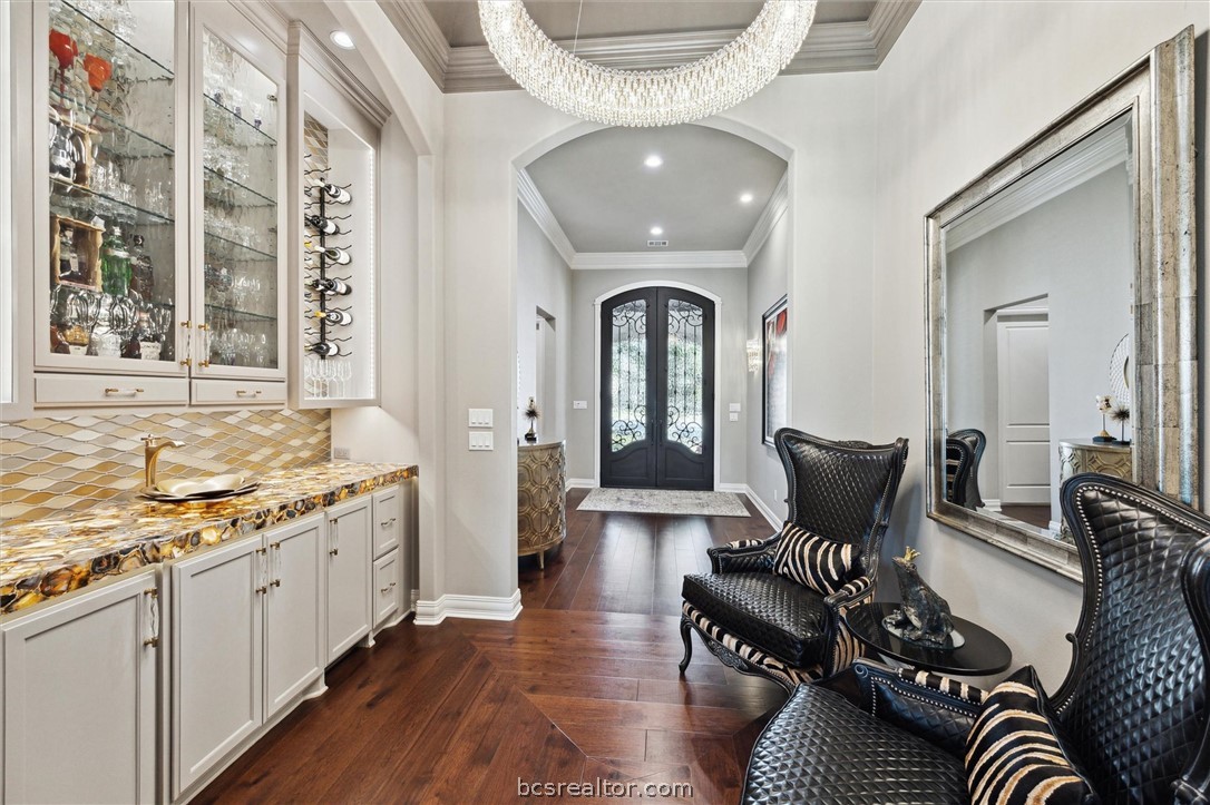 5202 Bourrone Court Bryan, TX 77802 - Photo 18 of 43 Foyer featuring arched walkways, wine storage/display and a Swarovski crystal chandelier.