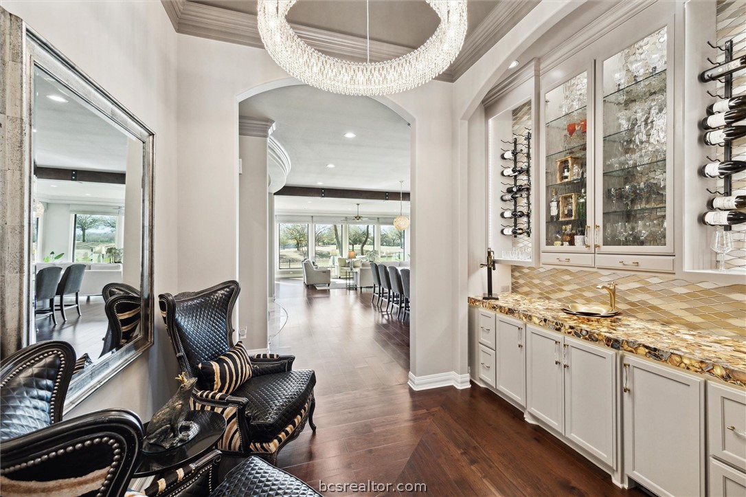 5202 Bourrone Court Bryan, TX 77802 - Photo 19 of 43 Bar featuring arched walkways, underlit granite/stone countertop, wine storage, ice maker and a unique Thompson vessel sink