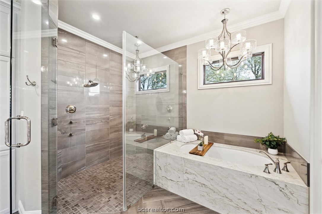 5202 Bourrone Court Bryan, TX 77802 - Photo 26 of 43 Drop-in granite-encased bathtub with chandelier and large spa like shower.