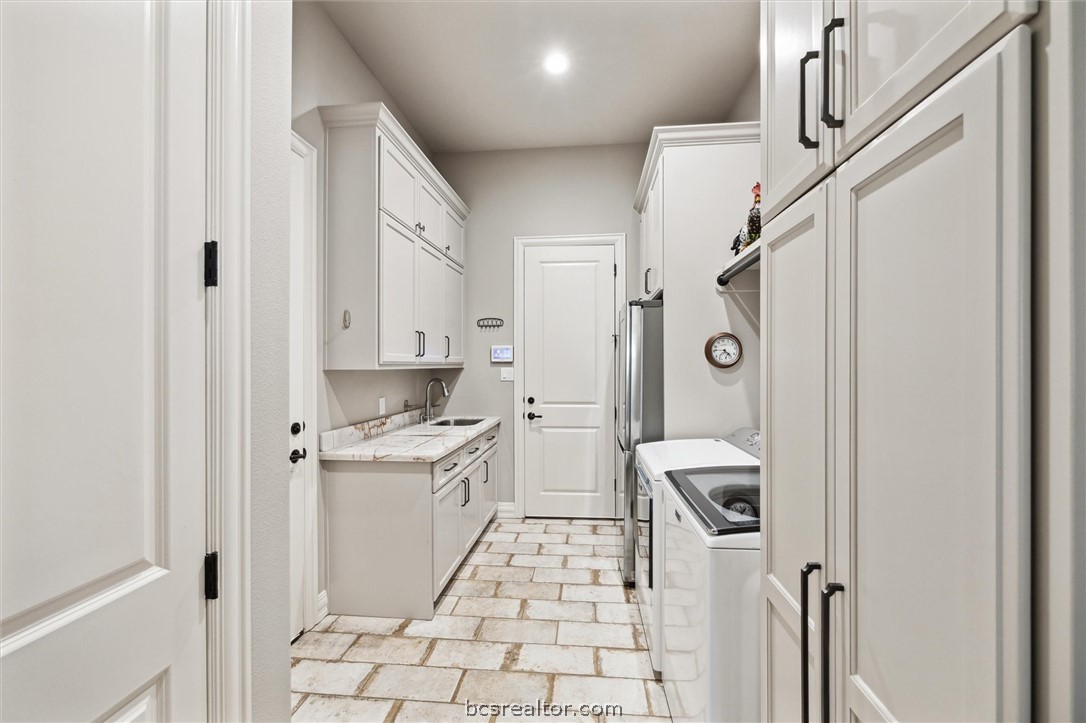 5202 Bourrone Court Bryan, TX 77802 - Photo 33 of 43 Laundry Room with brick floor, a sink, and abundence of cabinet space