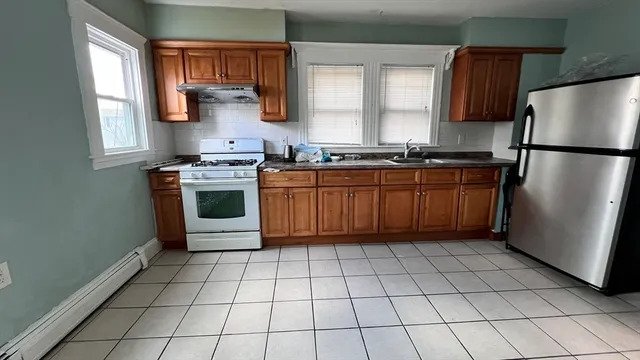 a kitchen with stainless steel appliances granite countertop a refrigerator sink and stove