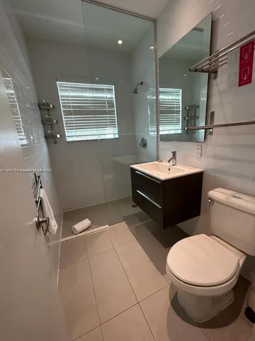 a bathroom with a sink a toilet and mirror
