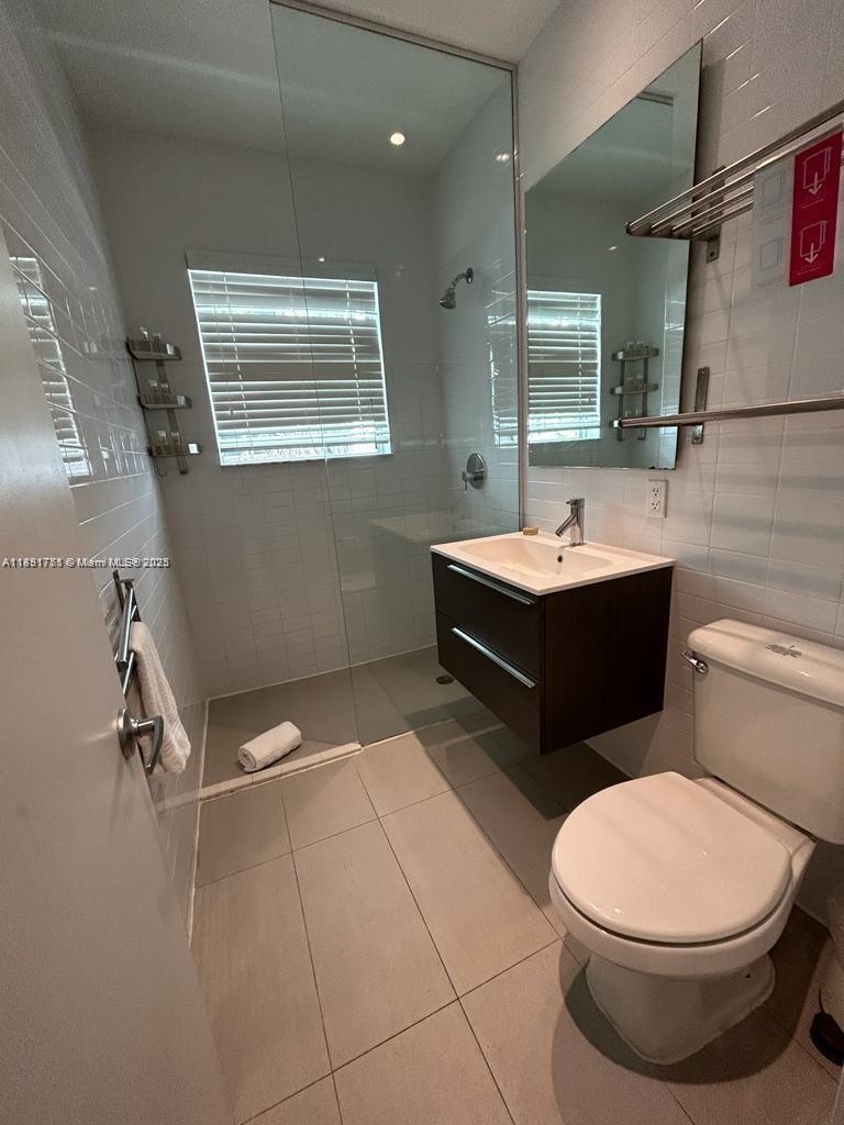 1816 Meridian Avenue, Unit 18 Miami Beach, FL 33139 - Photo 13 of 19 a bathroom with a sink a toilet and mirror