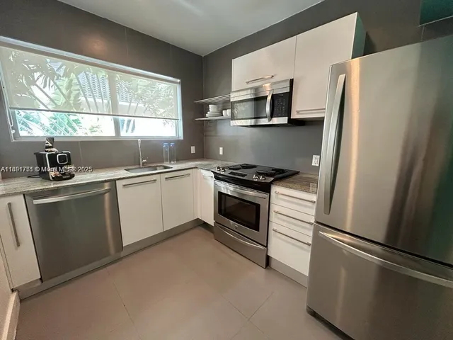 a kitchen with stainless steel appliances a refrigerator sink and stove