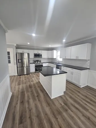 a view of a room with wooden floor and electronic appliances