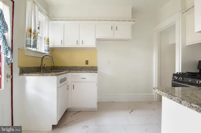 a kitchen with granite countertop a sink and a stove top oven