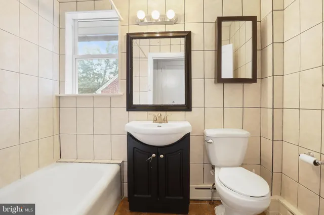 a bathroom with a sink a toilet and mirror