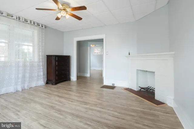 a view of an empty room with a fireplace and a window
