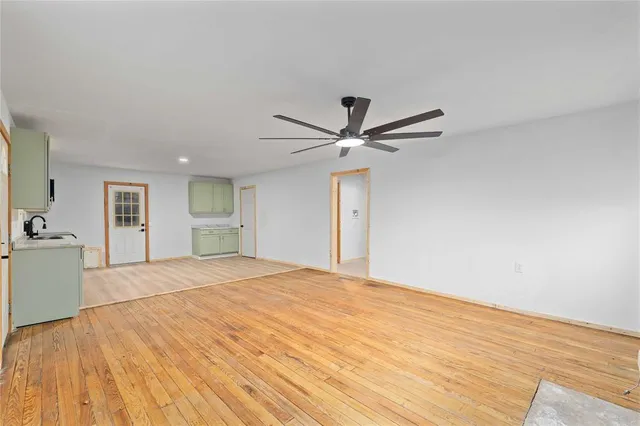 a view of empty room with wooden floor and fireplace