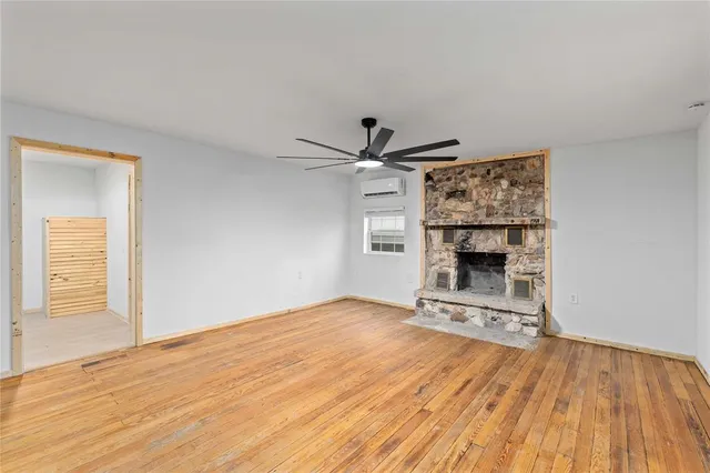 a view of empty room with wooden floor and fireplace