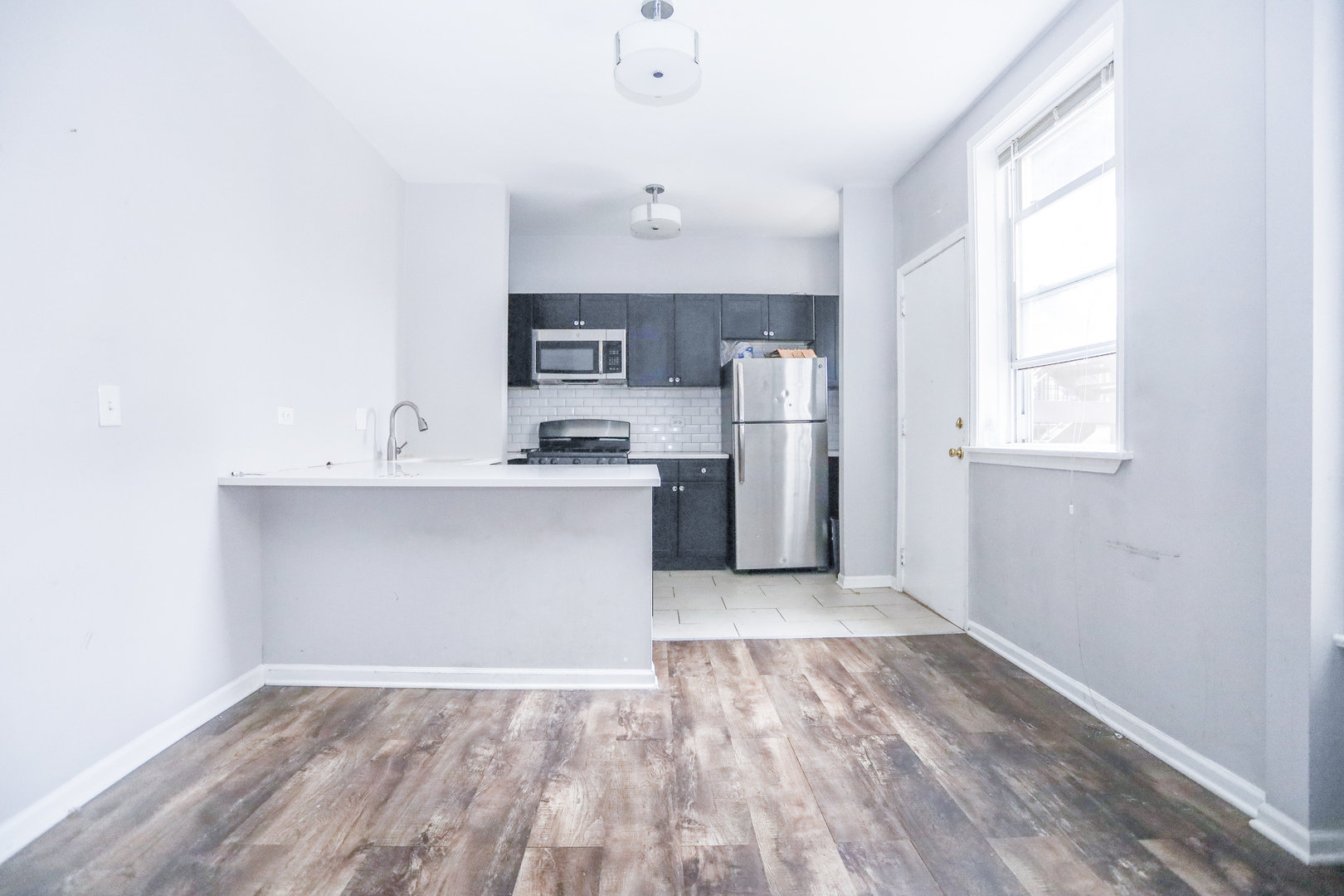 4400 North Magnolia Avenue, Unit 321 Chicago, IL 60640 - Photo 2 of 12 a view of a kitchen with a sink cabinets and wooden floor